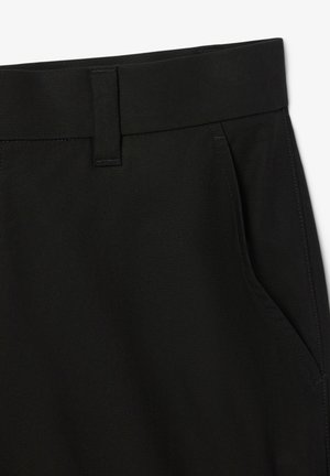 Schwarze Hosen mit glatter Textur, ausgestattet mit einem flachen Bund, schrägen Seitentaschen und kontrastierenden Steppdetails.