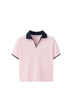 Polo de manga corta de color rosa claro con cuello negro y ribete negro en los bordes de las mangas sobre fondo blanco.