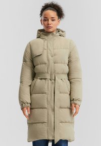 Bež dolg plašč z oblazinjenjem in kapuco, z pasom in zapiranjem na gumb; ima elastične manšete in vodoravno šivanje za dodatno teksturo.