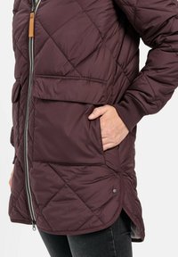 Burgunderfarbige gesteppte Jacke mit einem Frontreißverschluss, zwei Taschen und gerippten Manschetten. Verfügt über einen leicht abgerundeten Saum und eine glatte Textur.