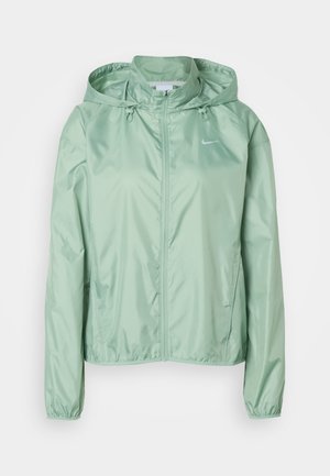 Ανοιχτό πράσινο αδιάβροχο μπουφάν Nike με κουκούλα, πλήρες φερμουάρ μπροστά, κορδόνια και ελαστικά μανίκια, εμφανίζεται σε λευκό φόντο.