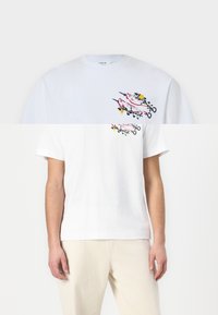 Balta kokvilnas T-shirts ar krāsainu grafisko drukājumu ar augiem un putniem uz priekšpuses. Klasisks apaļais kakls un īsās piedurknes.