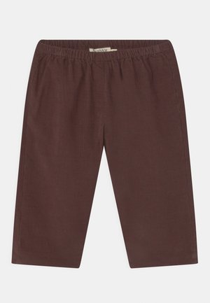 Brązowe spodnie z elastycznym stanem, skrócone, wykonane z sztruksu, rozłożone płasko na białym tle.