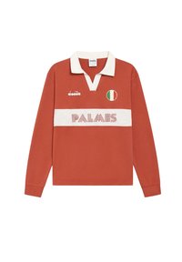 Polo a maniche lunghe di colore arancione bruciato, con colletto bianco e fascia orizzontale con testo "PALMES"; emblema della bandiera italiana sul petto. Materiale in cotone.