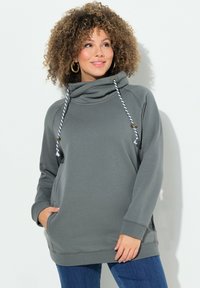 Felpa grigia con collo a cowl, dotata di lacci, maniche lunghe, tasche laterali e polsini a costine. Tessuto morbido con vestibilità comoda.