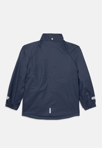 Marineblå vanntett jakke med høy krage, elastiske mansjetter og reflekterende detaljer. Glatt tekstur, lange ermer og en avslappet passform.