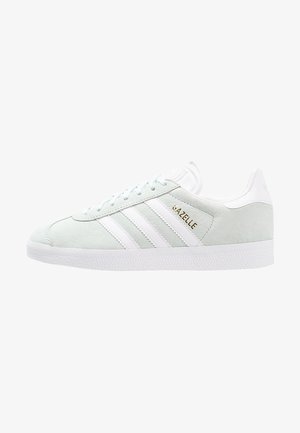 Světlé mátové zelené semišové tenisky s bílými koženými pruhy, bílou podrážkou a zlatým logem "Gazelle" po straně. Design s kulatou špičkou.