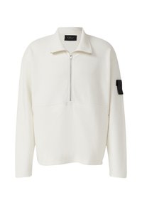 Weißer Fleece-Pullover mit halb offener Reißverschluss, Stehkragen und einem schwarzen Stoffpatch am linken Ärmel, der einen Knopf trägt.