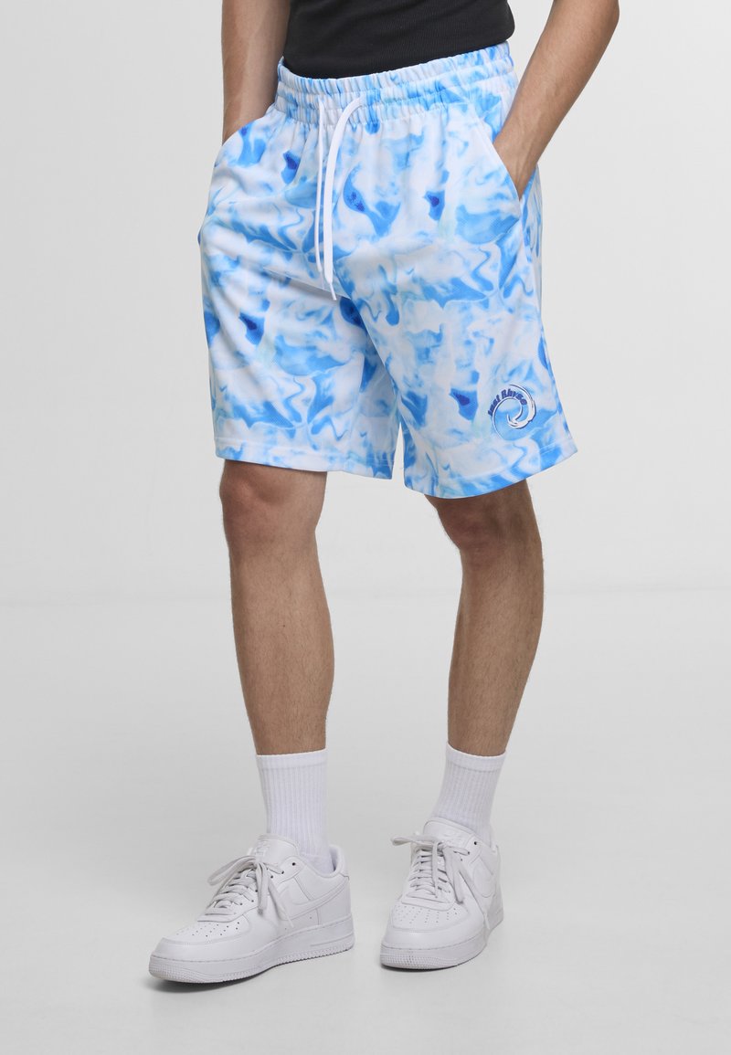 Lys blå mønstrete badeshorts med snøring i midjen og sidelommer, med en bølgelogo på leggen og kombinert med hvite joggesko.