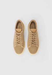 Ζευγάρι μπεζ υφαντά sneakers από σουέτ με κορδόνια στο μπροστινό μέρος και κρεμ ελαστική σόλα, με το λογότυπο "GANT" στη γλώσσα και την εσωτερική σόλα.