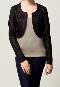 Svart kortärmad jacka med långa ärmar, texturert tyg, rundad halsringning, två framfickor och knappeker. Bärs över en beige topp.