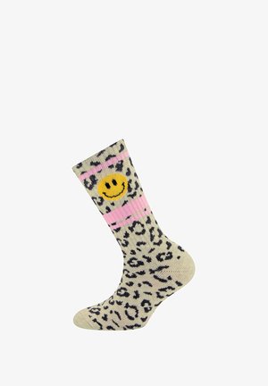 Chaussette en motif léopard avec une base crème, des taches noires et des rayures roses, décorée d'un visage souriant jaune à l'avant. Texture tricot douce.