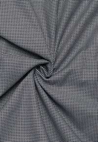 Gewebter Stoff in Marineblau und Grau mit einem geometrischen Muster, das eine strukturierte Oberfläche und eine Spiralfalte für eine dynamische Präsentation aufweist.