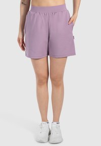 Pantalones cortos deportivos morados, hechos de una tela suave, con una cintura elástica y dos bolsillos laterales; dobladillo limpio y ajuste relajado.