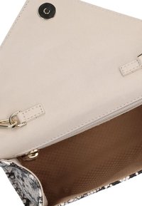 Compacte clutchtas met een zwart-wit slangenprint aan de buitenkant, een crèmekleurig interieur en gouden hardware details met druksluiting.
