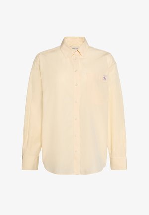 Beige overhemd met lange mouwen, knopen aan de voorkant, een borstzak en een klein Calvin Klein-logo op de zak, klassieke kraag en knoopmanchetten.