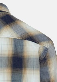 Kariertes Flanellhemd in Beige-, Marineblau- und Blautönen. Mit gewebter Textur und kontrastierenden Fäden entlang des Kragens und der Schultern.