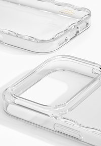 Przezroczyste etui na telefon z zaokrąglonymi krawędziami, gładką teksturą, precyzyjnymi wycięciami na przyciski i porty oraz tłoczonym logo wewnątrz.