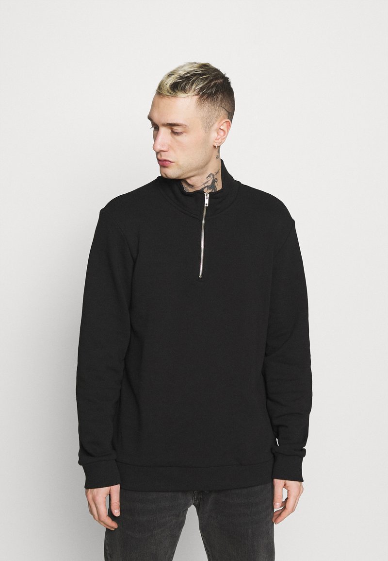 Zwarte zip-up sweatshirt met hoge kraag, voorzien van een zilveren rits, lange mouwen en geribde manchetten en onderrand. Gladde textuur, casual ontwerp.