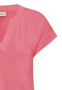 Chemise rose à manches courtes avec col en V, col cranté et coutures visibles aux manches et à l'encolure.