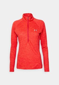 Rode top met lange mouwen en een kwartritssluiting, uitgevoerd in een textuur gebreid patroon. Heeft raglanmouwen en een klein logo op de borst. Zacht, sportief materiaal.