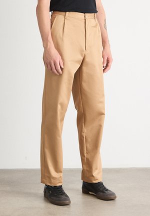 Beige chinos with a straight cut, featuring a button closure and side pockets. Made of smooth fabric, showcasing a wrinkle-resistant finish.