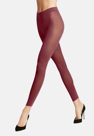 Beneden benen met doorzichtige bordeauxrode panty's en zwarte hoge hakken, geplaatst in een loopstand tegen een effen achtergrond.