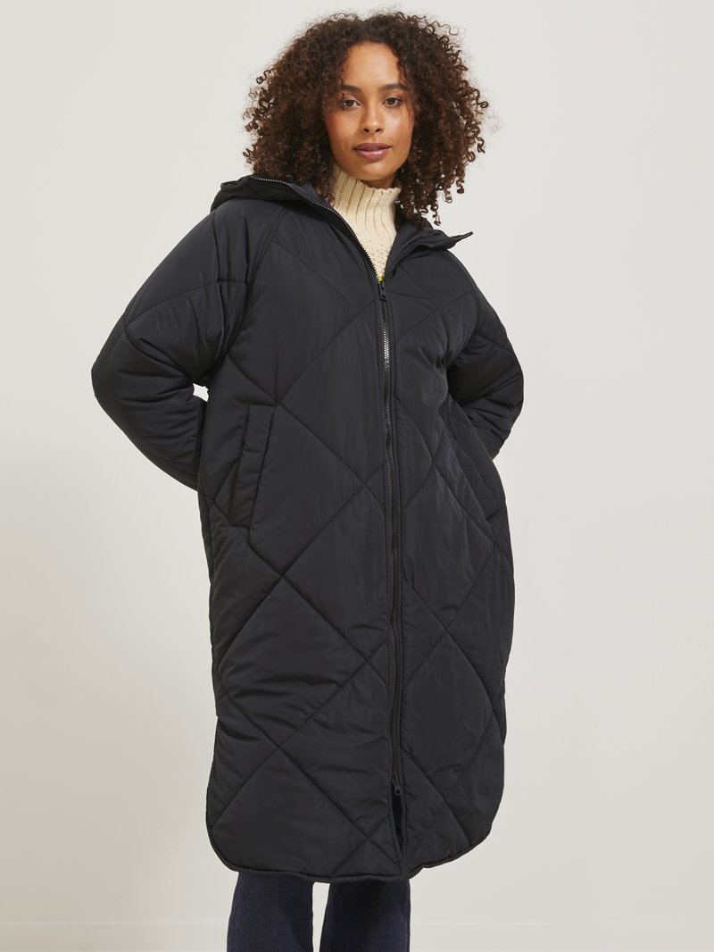 Manteau long noir matelassé avec capuche, présentant une fermeture éclair à l'avant et des manches larges, accentué par un motif en diamant et une texture douce.