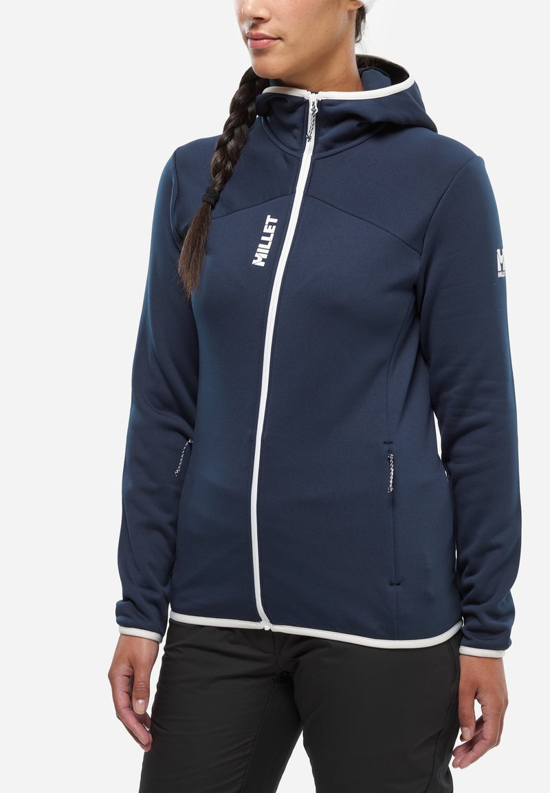 Granatowa bluza z kapturem na pełny zamek i białymi akcentami, wykonana z miękkiego, teksturowanego materiału. Posiada kaptur oraz kieszenie na zamek.