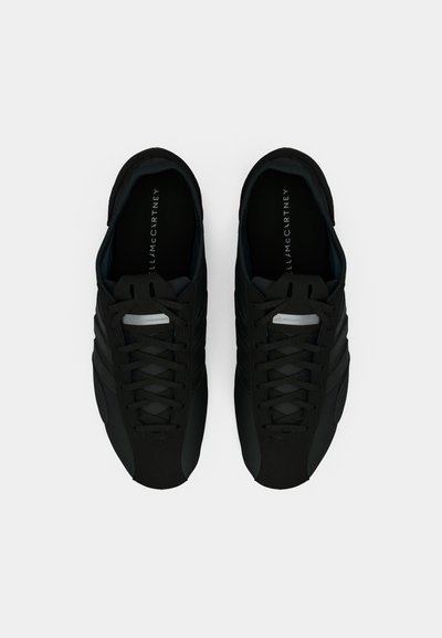 Μαύρα αθλητικά παπούτσια με κομψό σχεδιασμό, με υφή στο επάνω μέρος, δομημένο σύστημα κορδονιών και διακριτικό branding στις εσωτερικές σόλες.