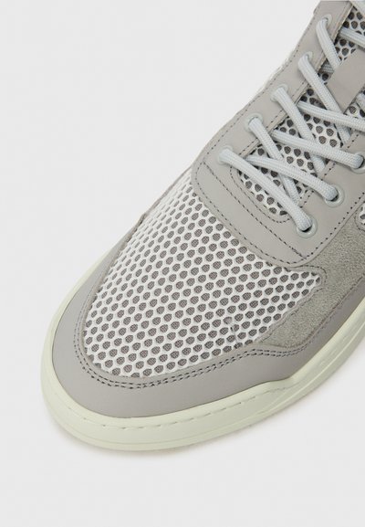 Gray sneaker featuring a mesh upper, suede accents, perforated design, and round laces with a rubber sole.