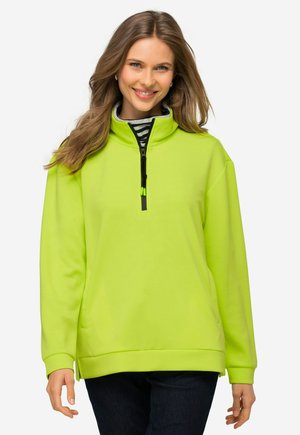Pullover verde neon con collo a mezza zip, caratterizzato da maniche lunghe e un taglio rilassato. La texture liscia e le tasche laterali ne migliorano la funzionalità.