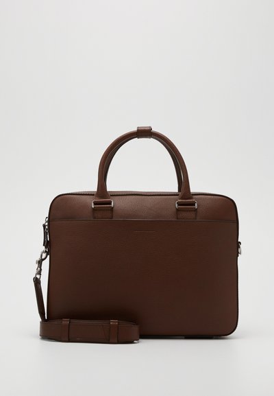 Sac en cuir marron pour ordinateur portable avec doubles poignées supérieures, bandoulière détachable, fermeture éclair et design minimaliste. Surface texturée.