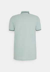 Polo à manches courtes bleu clair avec bordures noires sur le col et les bords des manches, vu de dos sur un fond blanc.