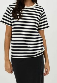 Randig svart-och-vit t-shirt med korta ärmar och rund halsringning, tillverkad av mjukt tyg, med en avslappnad passform och sid sömsdetalj.