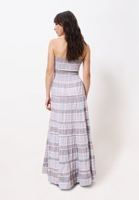 Trägerloses Maxikleid in einem blau-weißen Karomuster, mit einem gerafften Oberteil und einem gestuften Rock mit dezenten Rüschendetails.