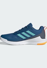 Scarpa da atletica blu navy con strisce blu chiaro, suola bianca e tab per il tallone arancione, mostrata dal lato esterno su uno sfondo neutro.