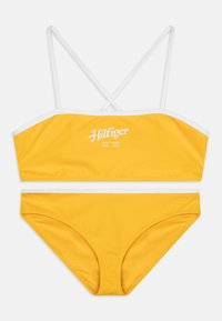 Yellow bikini set featuring a bandeau top with white trim and crossed straps, paired with matching low-rise bottoms. Cotton-like texture.