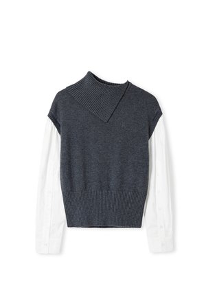 Maglione grigio a maglia con colletto a coste e design corto, indossato sopra una camicia bianca a maniche lunghe con dettagli di bottoni sulle maniche.