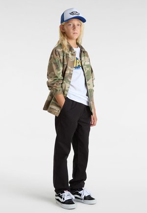Camo-takki, valkoinen t-paita sinisellä logolla, mustat housut ja mustat Vans-kengät. Lippis on sinivalkoinen, jossa on logo.
