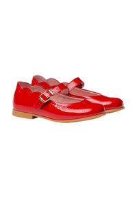 Zapatos Mary Jane de charol rojo con borde en forma de ondas y una sola correa con hebilla, con un tacón bajo marrón y punta redonda.