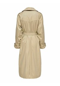 Long trench-coat beige avec ceinture, épaulettes et sangles aux poignets, vu de dos sur fond blanc.