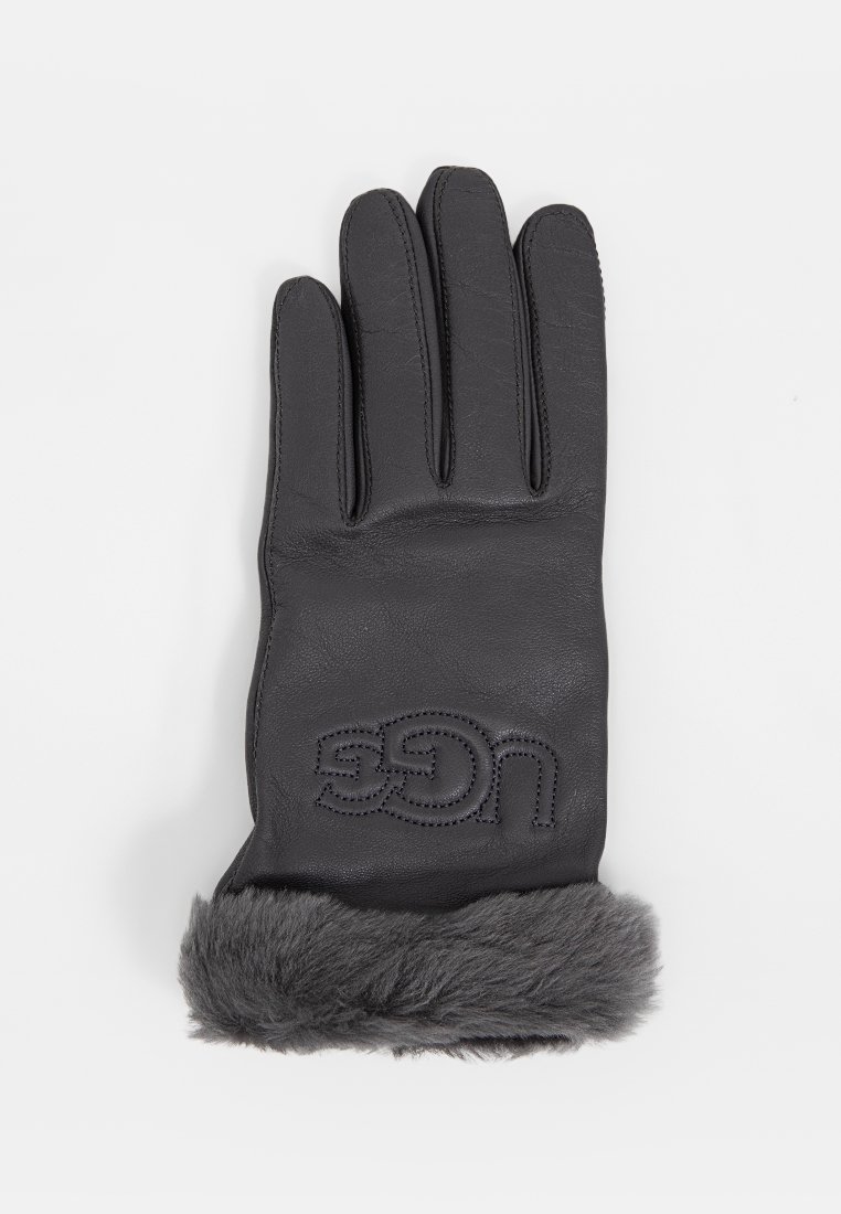 Schwarze Lederhandschuhe mit einem grauen Pelzaufschlag. Mit eingeprägtem UGG-Markenlogo auf der Handfläche. Glatte Textur mit Design für fünf Finger.