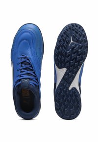 Zilā sporta apaviem ir eleganta, gluda ādas augšdaļa ar strukturālajiem akcentiem. Zolei ir izteikta raksta virsma, kas nodrošina saķeri.