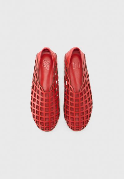 Pantofi slip-on roșii cu un model în carouri, realizați dintr-un material flexibil, având un căptușeală interioară netedă și un design cu vârf rotunjit.
