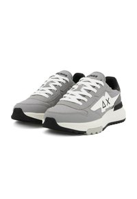 Sneaker grigie con una combinazione di materiali lisci e testurizzati, dettagli bianchi, inserti in rete e una suola nera a contrasto.