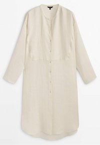 Robe-chemise à manches longues, crème, boutonnée, avec un col rond et un ourlet légèrement arrondi.