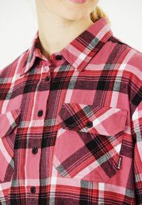 Rot-schwarz kariertes Flanellhemd mit langen Ärmeln, Button-Down-Kragen, zwei aufgesetzten Taschen und schwarzen Knöpfen. Aus einem strukturierten Baumwollstoff gefertigt.