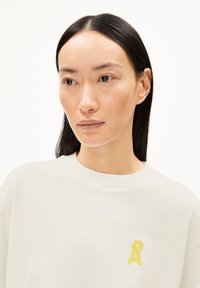 Crewneck sweatshirt in off-white katoen, met een gestructureerd geel logo op de borst, lange mouwen en een ontspannen pasvorm.