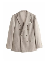 Svetlo béžové dvojradové sako so širokými klopami, šiestimi gombíkmi, dvoma prednými vreckami s klopou a bielym vreckovkou v hrudnom vrecku.